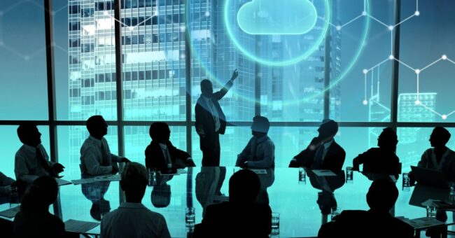 Executive team in a modern boardroom reviewing Cloud ERP Benefits, with a digital cloud icon and data connections illustrating real-time financial visibility, scalability, and secure cloud-based business management.