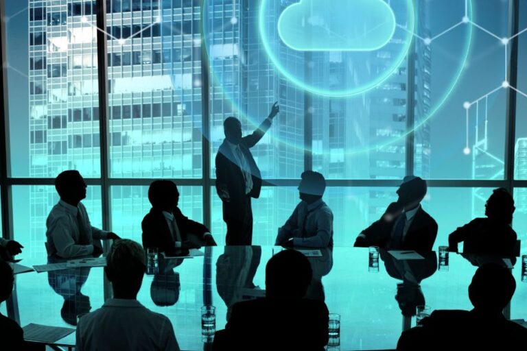 Executive team in a modern boardroom reviewing Cloud ERP Benefits, with a digital cloud icon and data connections illustrating real-time financial visibility, scalability, and secure cloud-based business management.