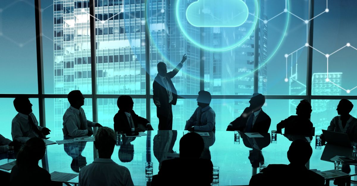 Executive team in a modern boardroom reviewing Cloud ERP Benefits, with a digital cloud icon and data connections illustrating real-time financial visibility, scalability, and secure cloud-based business management.