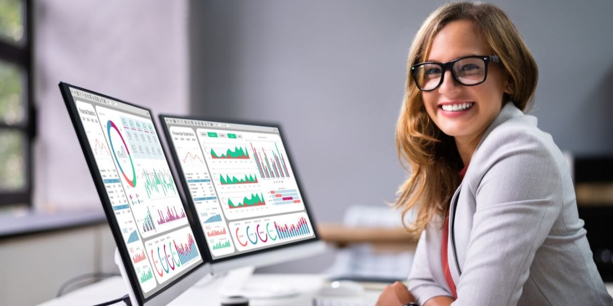 Professional reviewing Microsoft Dynamics 365 Business Central Analytics dashboards displaying real-time financial and operational data visualizations for business performance analysis.